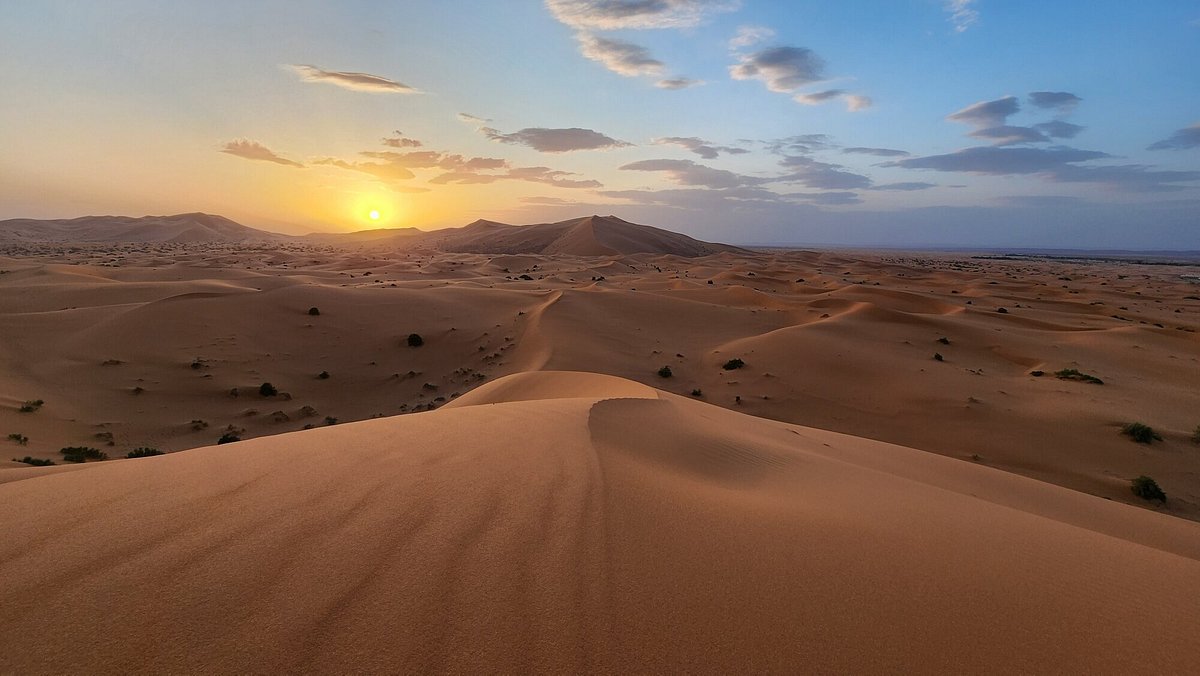 The golden sand dunes of Erg Chebbi in Merzouga at sunset, hiding millions of years of history